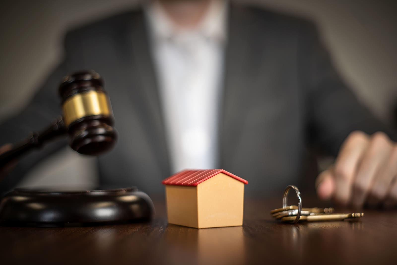 A gavel, keys and a model house at a property auction