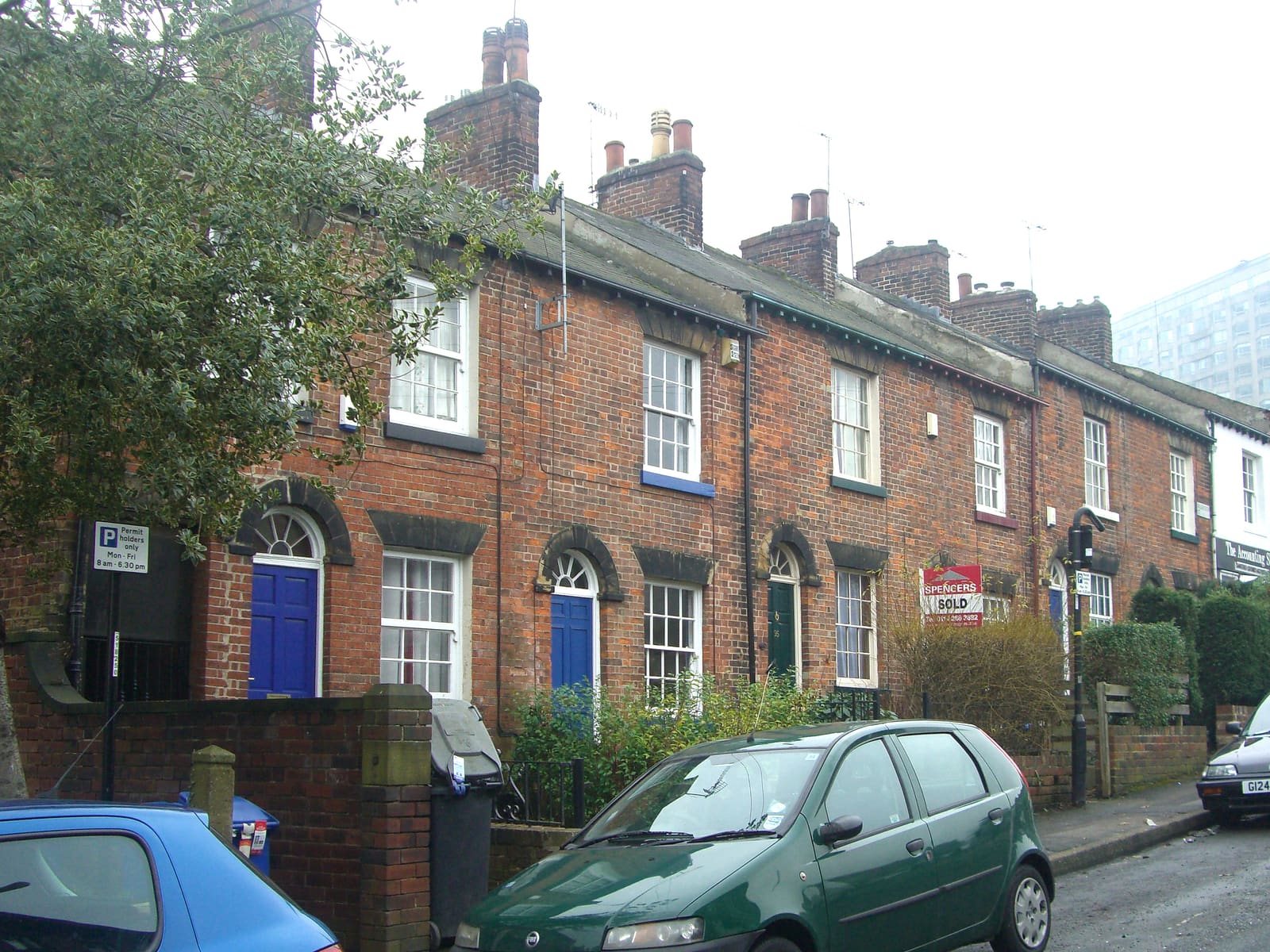 A sold sign outside a red-brick terraced house in England